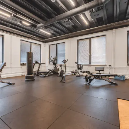 Een kantoorpand aan de Lange Kleiweg 50-62 in Rijswijk met een fitnessruimte, compleet met verschillende fitnessapparaten en enkele banken, biedt mogelijkheden voor kantoorruimte huren met goede voorzieningen.