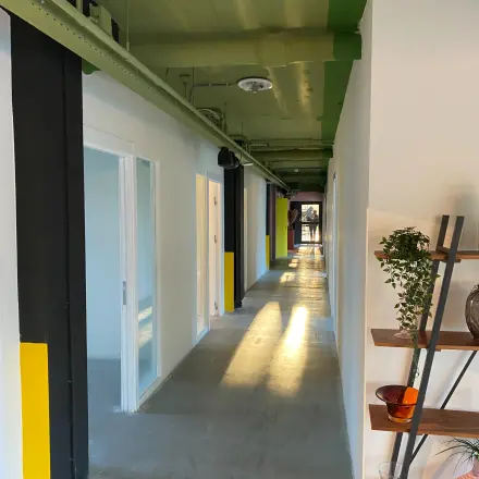Kantoorpand aan de Volmerlaan 7 in Rijswijk met lange, lichte gang en modern industrieel ontwerp. Bekijk de mogelijkheden voor kantoorruimte huren.