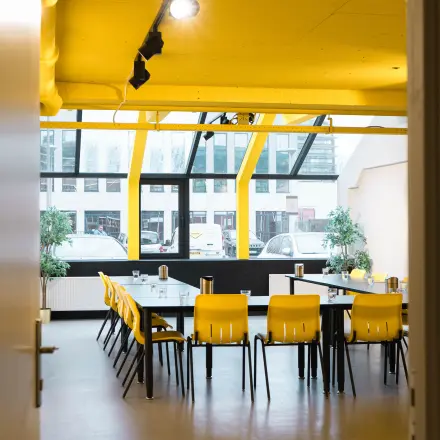Vergaderruimte in een kantoor aan de Volmerlaan 7, Rijswijk, met gele stoelen en glazen wanden. Ideaal voor bedrijven die kantoorruimte huren en vergaderingen willen organiseren.