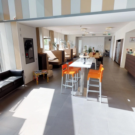 Kantoorruimte te huur in Roermond met moderne inrichting, hoge ramen en een uitnodigende sfeer. Het kantoorpand heeft comfortabele zitplaatsen en een gemeubileerd interieur. Ideaal voor werk of informele bijeenkomsten.