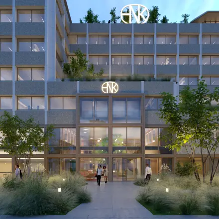 Moderne gevel van een kantoorpand aan de Marten Meesweg 101 in Rotterdam Alexander met verlichte glazen entree en enkele mensen die naar binnen gaan.