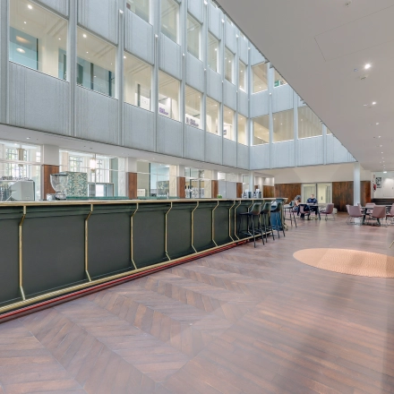 Moderne kantoorruimte te huur op Blaak 34, Rotterdam Centrum, met een ruime, open indeling en comfortabele zitplekken. Zakelijke activiteiten zijn zichtbaar in deze lichte en uitnodigende omgeving.