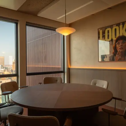 Vergaderruimte in een kantoorpand op Coolsingel 139, Rotterdam Centrum met ronde tafel, stoelen en uitzicht op de stad. Ideaal voor kantoorruimte huren met een inspirerende setting.