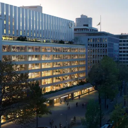 Buitenkant van een modern kantoorpand aan de Coolsingel 75 in Rotterdam Centrum, perfect voor wie kantoorruimte wil huren. Het gebouw is omringd door groen en heeft grote ramen voor veel natuurlijk licht.