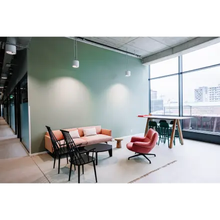 Moderne en lichte kantoorruimte huren in een kantoorpand op Hoogstraat 185, Rotterdam Centrum, met comfortabele meubels, grote ramen en uitnodigende zithoek.