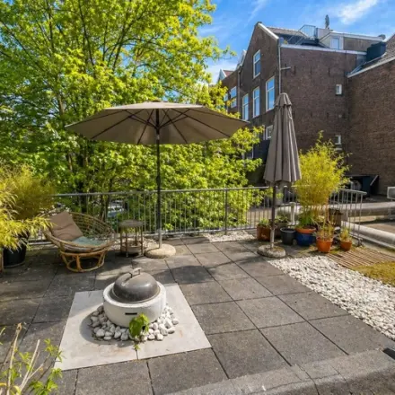Dakterras van kantoorpand op Mauritsweg 33 A01 in Rotterdam Centrum, met parasols, planten en een zitgedeelte. Geschikt voor kantoorruimte huren met ontspanningsmogelijkheden buiten.
