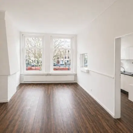 Kantoorruimte op Mauritsweg 33 A01 in Rotterdam Centrum met houten vloer, witte muren en veel natuurlijk licht via twee grote ramen. Ideaal voor kantoorpand dat te huur is.