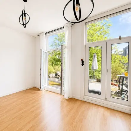 Lichte kantoorruimte met houten vloer, grote ramen en zicht op groen, ideaal voor kantoorruimte huren. Gelegen op Mauritsweg 33 A01 in Rotterdam Centrum.