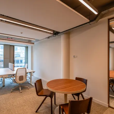 Moderne kantoorruimte te huur op Stadhuisplein 9-23 in Rotterdam Centrum met vergadertafel, bureaus en ergonomische stoelen voor optimaal werken.