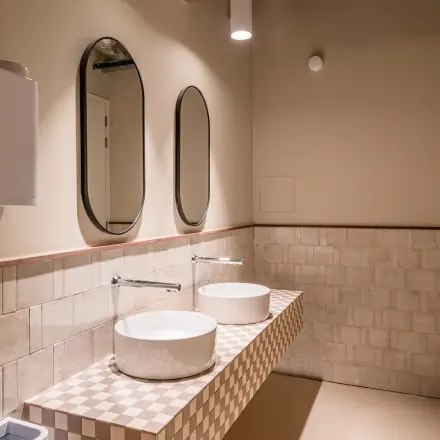 Moderne badkamer in kantoorpand Stadhuisplein 9-23, Rotterdam Centrum, met twee wastafels en spiegels. Beschikbaar voor kantoorruimte huren.