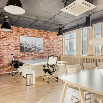 Moderne kantoorruimte in kantoorpand aan Veerhaven 7, Rotterdam Centrum met bakstenen muur en grote ramen. Ideaal om te huren voor een inspirerende werkplek.