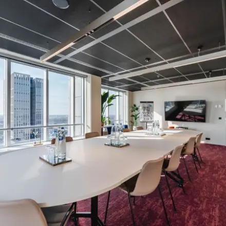 Modern kantoorpand in Rotterdam Centrum, gelegen op Weena 690, met een stijlvolle vergaderruimte voorzien van een lange tafel, comfortabele stoelen en grote ramen voor natuurlijk licht.