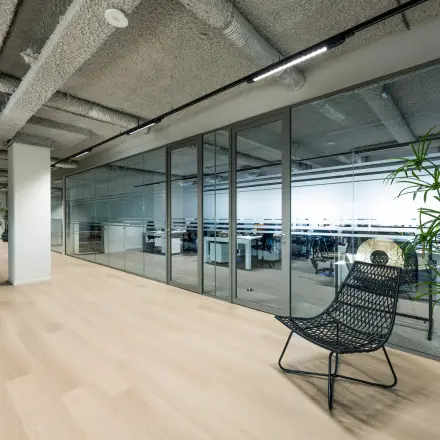 Moderne kantoorruimte te huur op Westblaak 180, Rotterdam Centrum, met glazen wanden, open werkplekken en een designstoel. Kantoorpand biedt lichte en strakke omgeving voor huurders.