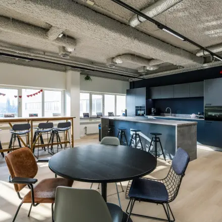 Moderne kantoorruimte te huur op Westblaak 180, Rotterdam Centrum, met open keuken en zitgedeelte, veel daglicht en stijlvolle meubels.