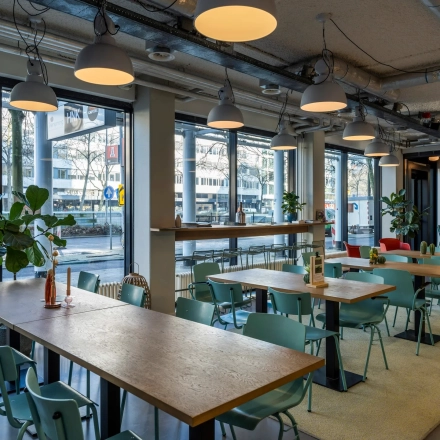 Kantoorruimte in Rotterdam Centrum aan Westblaak 180 met moderne inrichting en grote ramen. Ideaal om te huren als werkruimte, voorzien van tafels en stoelen onder sfeerverlichting.