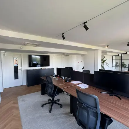 Moderne kantoorruimte op Westplein 12, Rotterdam Centrum met werkplekken voorzien van bureaus en stoelen, ideaal voor bedrijven die kantoor willen huren. Ruimte heeft een strakke, professionele uitstraling inclusief beeldschermen.