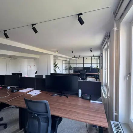 Moderne kantoorruimte met bureaus en stoelen op Westplein 12, Rotterdam Centrum. Voorzien van grote ramen voor natuurlijk licht. Ideaal voor wie kantoorruimte wil huren in een dynamische omgeving.