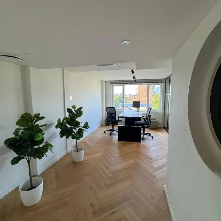 Stijlvolle kantoorruimte huren met houten vloer, veel lichtinval en moderne bureaus aan Westplein 12 in Rotterdam Centrum.