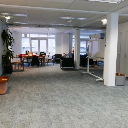 Kantoorruimte op Wijnhaven 76 in Rotterdam Centrum met diverse werkplekken en een vergadertafel. Ideaal om te huren voor zakelijke activiteiten.