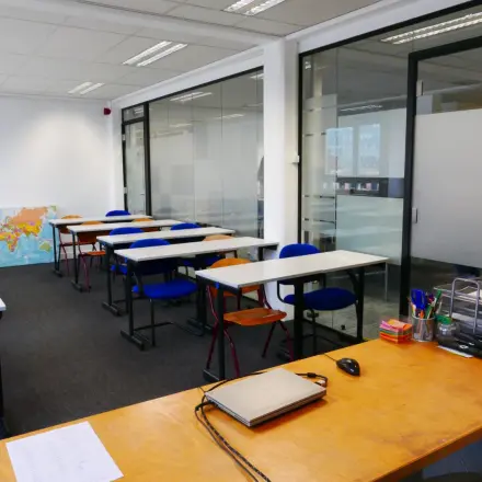 Kantoorruimte huren in Rotterdam Centrum met meerdere bureaus en stoelen. Het kantoorpand aan Wijnhaven 76 biedt een moderne werksfeer met strakke lijnen en veel natuurlijk lichtinval.