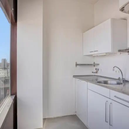 Compacte pantry in lichte kantoorruimte met uitzicht, ideaal voor kleine pauzes. Voorzien van een aanrecht en opbergruimte. Gelegen aan de Kratonkade in Rotterdam Delfshaven.