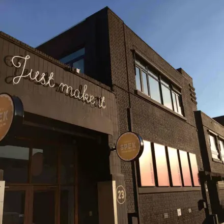 Industrieel kantoorpand aan Van Helmontstraat 17-23 in Rotterdam Delfshaven met moderne gevel en opvallend uithangbord, ideaal voor unieke kantoorruimte huren.