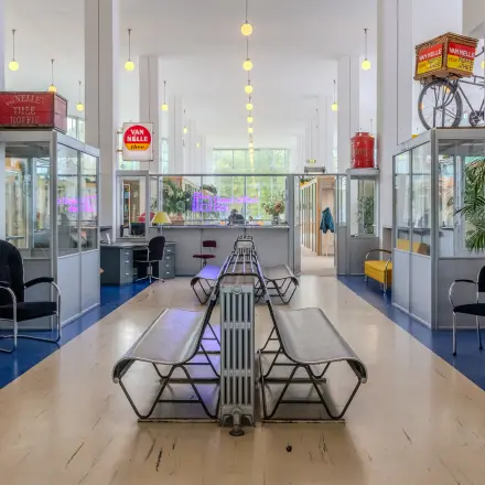 Lichte kantoorpand met klassieke banken en vintage decoratie aan Van Nelleweg 1 in Rotterdam Delfshaven, zonder mensen. Ideale ruimte voor kantoorruimte huren met een retro-touch.