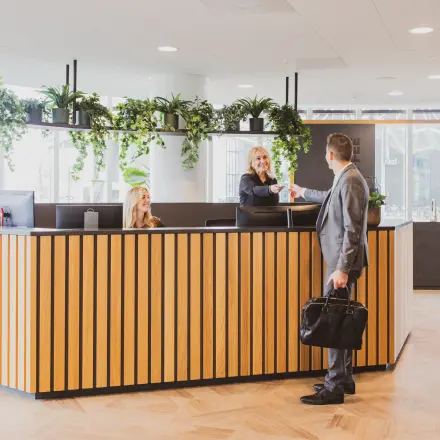 Moderne receptie in kantoorpand op Wilhelminaplein 1-40, Rotterdam Kop van Zuid, met vriendelijk personeel dat bezoekers verwelkomt. Ideaal voor kantoorruimte huren in een dynamische omgeving.