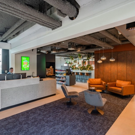 Moderne kantoorlounge in kantoorpand op Waalhaven O.z. 85, Rotterdam Waalhaven, met receptiebalie, sfeerverlichting en comfortabele zitruimte. Ideale plek voor kantoorruimte huren met aangename werkomgeving.