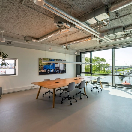 Moderne kantooruimte te huur aan Waalhaven O.z. 85 in Rotterdam, met grote ramen en vergadertafel, uitzicht op de haven.