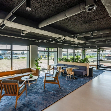 Moderne kantoorlounge in Rotterdam Waalhaven met comfortabele zitplaatsen en veel natuurlijk licht aan Waalhaven O.z. 85. Ideale plek voor huren van kantoorruimte in een levendige omgeving.