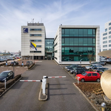 Exterieur van een modern kantoorpand aan de Waalhaven O.z. 85 in Rotterdam met ruime parkeergelegenheid en opvallende glazen gevels.