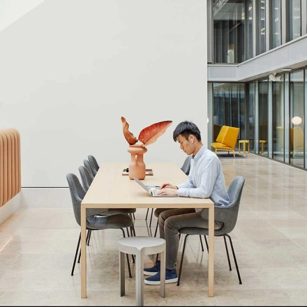 Binnenruimte van een kantoorpand op Evert van de Beekstraat 354, Schiphol Airport, met een persoon die aan een tafel werkt. Ruime, lichte en moderne werkruimte. Ideaal voor kantoorruimte huren.