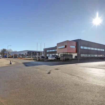 Buitenzijde van een kantoorpand op Fischerpad 106 in Sittard onder een heldere hemel. Het kantoorgebouw straalt een moderne en functionele uitstraling uit.