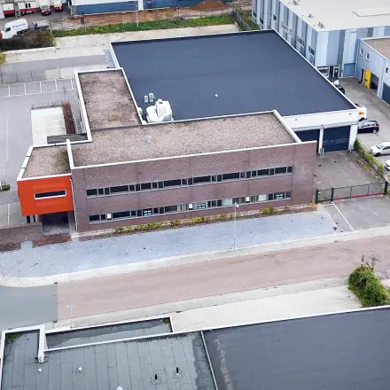 Luchtfoto van kantoorpand op Fischerpad 106 in Sittard met omliggende parkeerplaatsen.