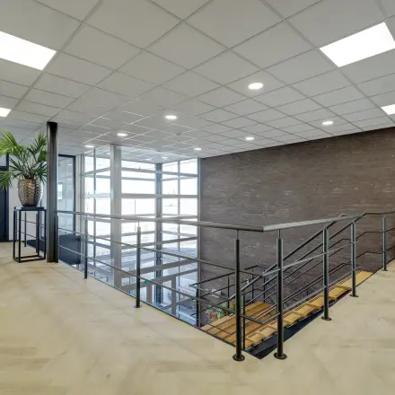 Lichte bovenverdieping in kantoorpand op Fischerpad 106, Sittard met modern trappenhuis en houten vloer. Ideaal voor wie een kantoorruimte wilt huren met een uitnodigende en professionele uitstraling.