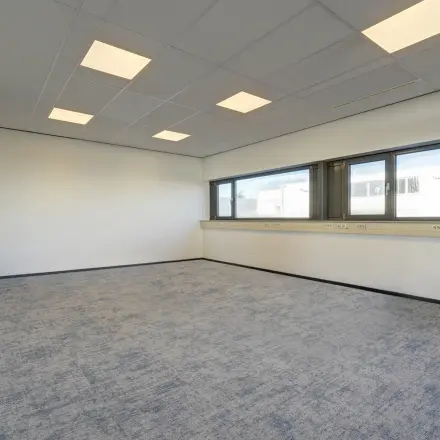 Lichte en ruime kantoorruimte te huur op Fischerpad 106, Sittard. Grote ramen bieden veel natuurlijk licht, ideaal voor diverse kantooropstellingen. Neutrale vloer en plafondverlichting complementeren de strakke uitstraling.