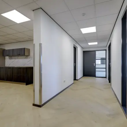 Moderne kantoorruimte met lichte houten vloer en geïntegreerde kitchenette op Fischerpad 106 in Sittard. Beschikbaar voor huur voor flexibele werkoplossingen.
