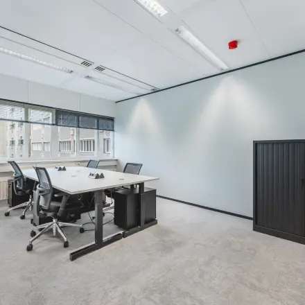 Kantoorruimte huren aan Leidseveer 2-10 in Utrecht Centraal Station. Een moderne en lichte kantoorruimte met enkele bureaus en stoelen, geschikt voor zakelijke activiteiten.