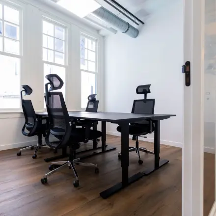 Moderne kantoorruimte te huur in Utrecht Centrum met vier bureaus, ergonomische stoelen en veel natuurlijk licht door grote ramen.