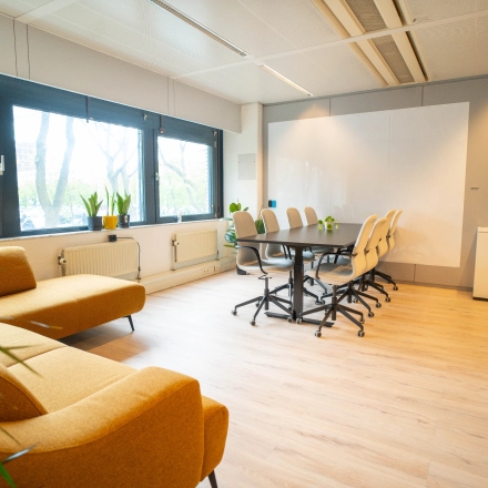 Kantoorruimte huren in Utrecht Kanaleneiland op Bernadottelaan 13 met lichte vergaderruimte voorzien van een houten vloer, comfortabele stoelen rond een grote tafel en grote ramen.