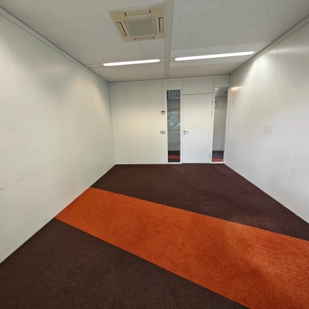 Ongemeubileerde kantoorruimte te huur in Utrecht Kanaleneiland, Bernadottelaan 13, met helder verlichte muren en kleurrijk tapijt.