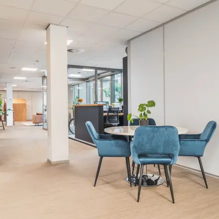 Kantoorruimte huren in Utrecht Papendorp met een open vloerplan. Het kantoorpand heeft een moderne inrichting met comfortabele blauwe stoelen rondom een tafel.