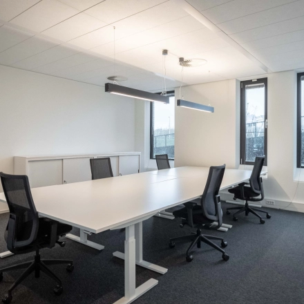 Een lichte en moderne kantoorruimte met vier bureaustoelen en een grote tafel, ideaal voor vergaderingen, op Van Deventerlaan 31-51 in Utrecht Papendorp.