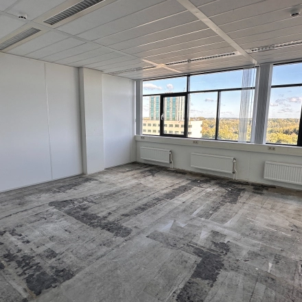 Lege kantoorruimte op Daltonlaan 200 in Utrecht Rijnsweerd met grote ramen, geschikt voor verhuur. Panorama-uitzicht op de stad en omliggende gebouwen.