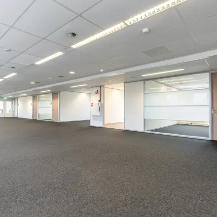Ruime, lichte kantoorruimte te huur in Veldhoven, De Run 1141-1157, met moderne plafondpanelen en grijze vloerbedekking. Geschikt voor open werkplekken of andere kantoorinrichting.