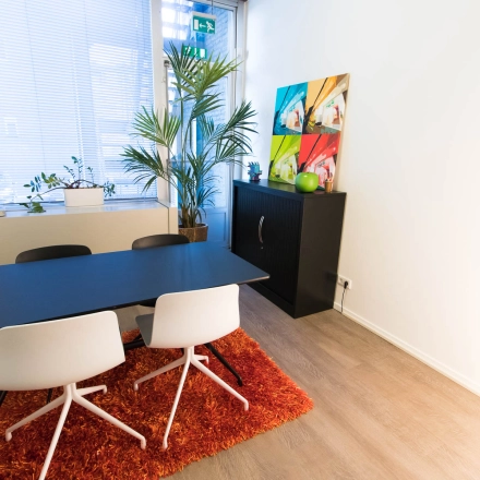 Kantoorruimte te huur op Kaldenkerkerweg 20 in Venlo met moderne inrichting, tafel, stoelen en kleurrijke muurkunst.