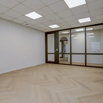 Leegstaande kantoorruimte te huur in Venray, Keizersveld 47, met houten vloer en glazen wanden.