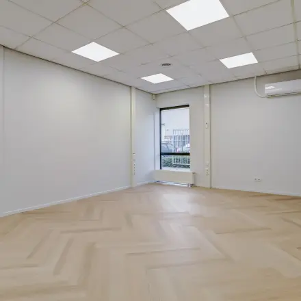 Ongemeubileerd kantoor te huur op Keizersveld 47 in Venray, met houten vloer en raam voor natuurlijk licht.