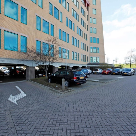 Parkeerplaats bij kantoorpand Loire 104 - 206 in Voorburg, met diverse auto's geparkeerd voor het gebouw.